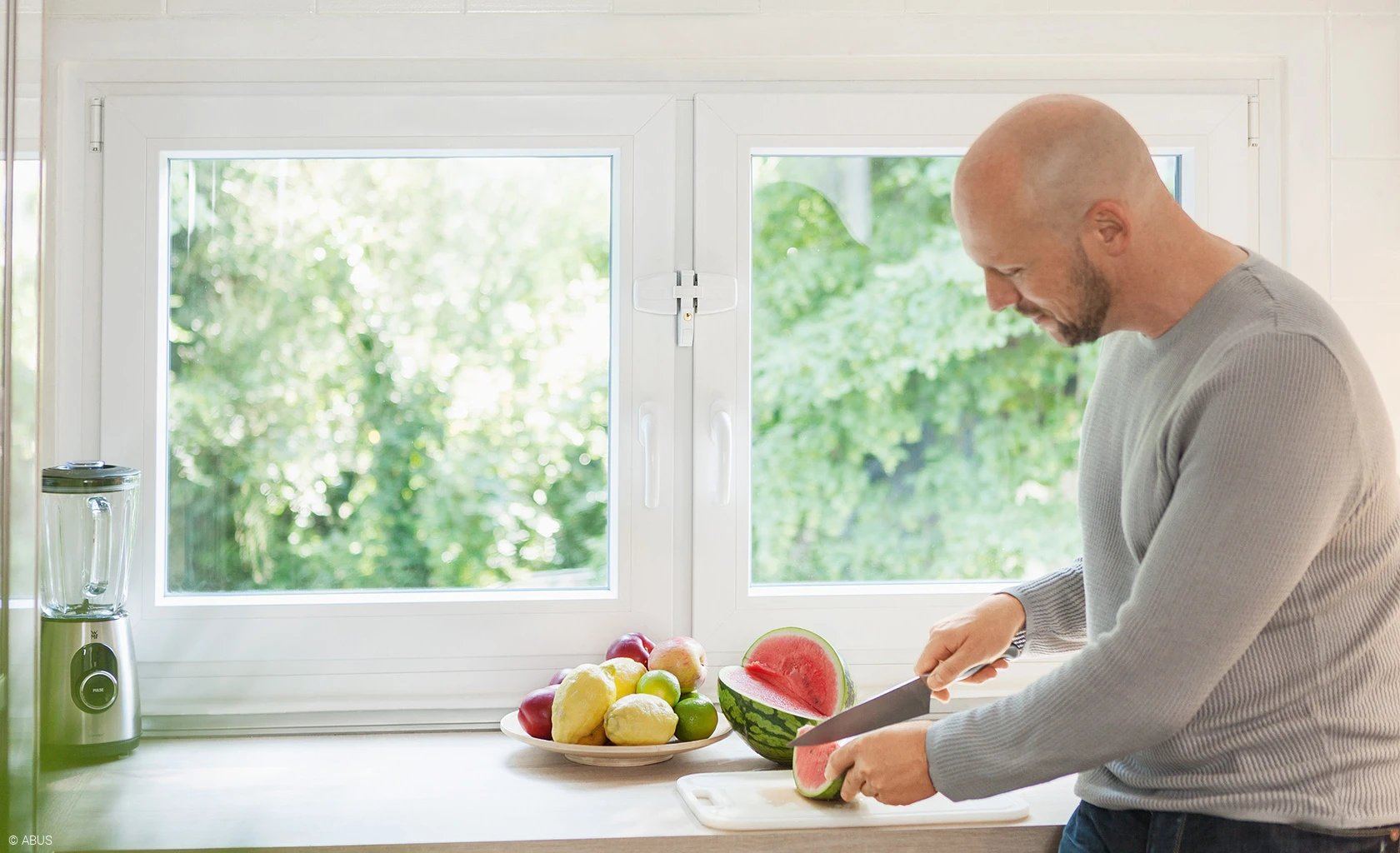 Person mit Fenstersicherung in der Küche